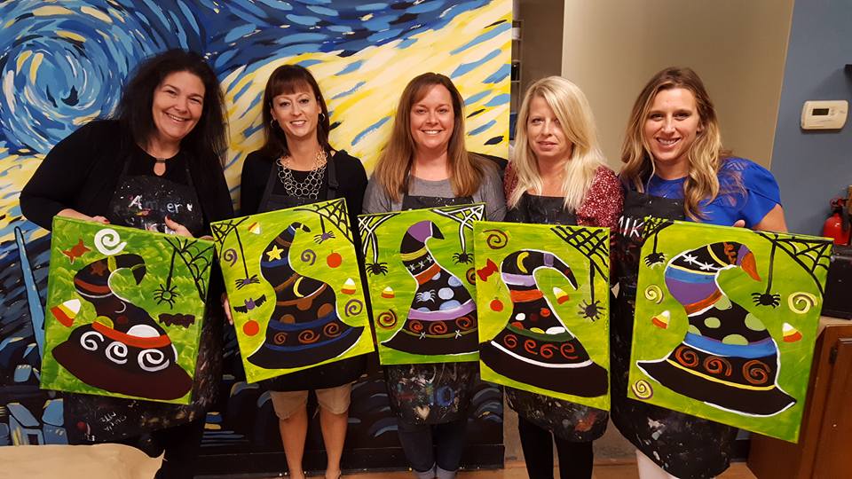 Friends with Starry Night witch hat canvases at a paint party